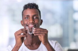 Black man with aligner from dentist